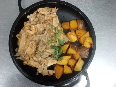Пательня з куркою - м'ясо курки, картопля, цибуля, печериці, часник, соус, зелень.